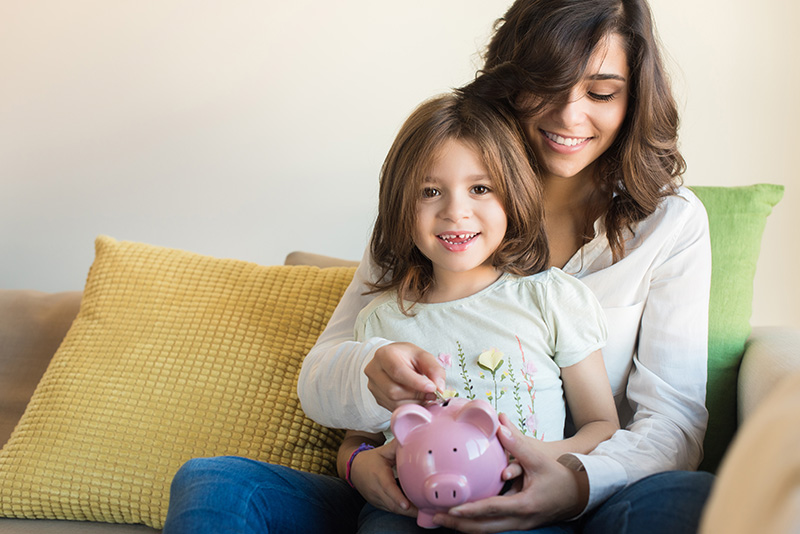 Mother and daughter with piggy bank